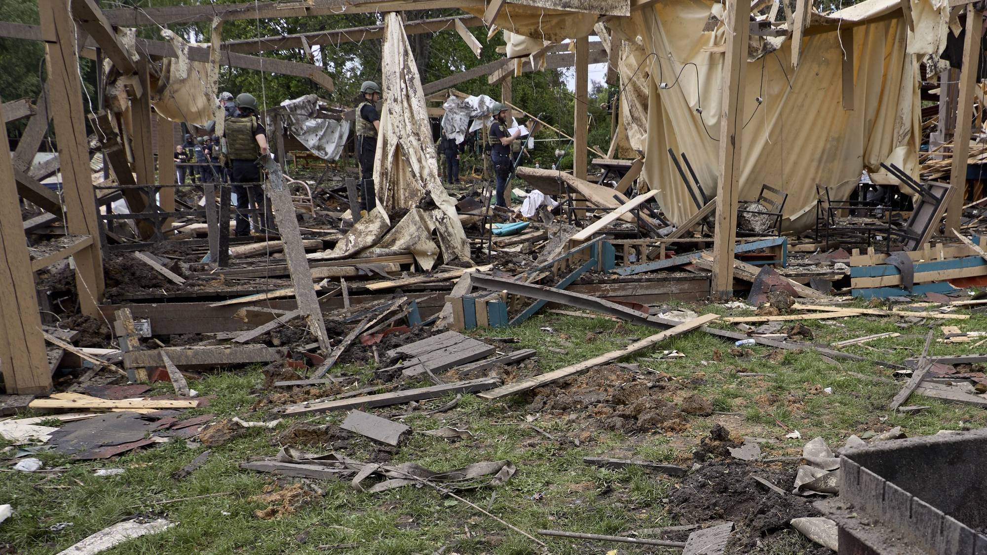 epa11353269 Ukrainian rescuers and policemen work at the site of a rocket strike on a recreation center on the shore of a reservoir in Kharkiv region, Ukraine, 19 May 2024, amid the Russian invasion. At least 5 people died and 16 were injured, including an 8-year-old child, as the result of the Russian rocket shelling of a recreation center according to an Emergency Service report. Russian troops entered Ukraine in February 2022 starting a conflict that has provoked destruction and a humanitarian crisis.  EPA/SERGEY KOZLOV