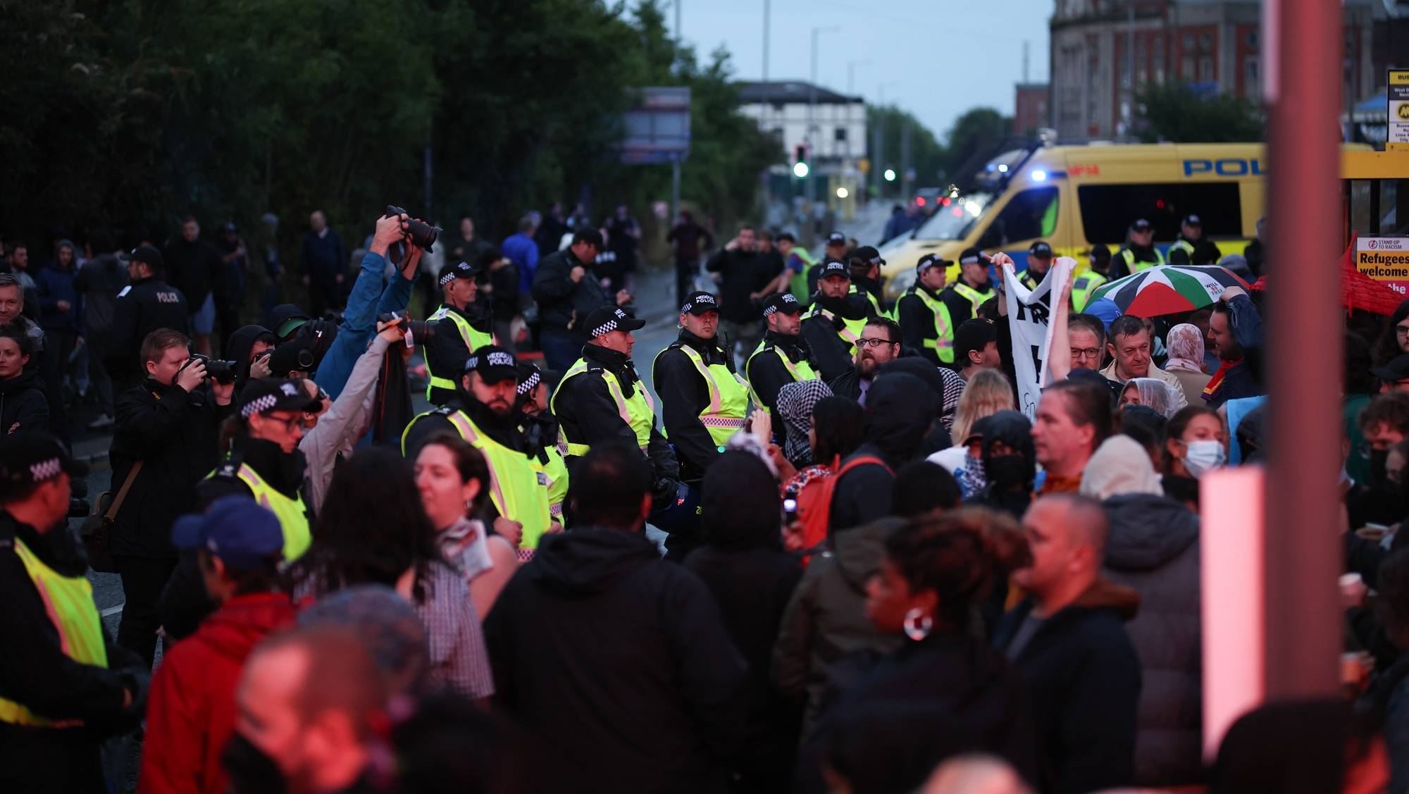 epa11520857 Police officers form a line separating protesters and counter-protesters during a demonstration at the Abdullah Quilliam Mosque in Liverpool, Britain, 02 August 2024. People gathered at the Liverpool mosque, which was the first in England, in response to the threat of far-right violence in the wake of the fatal Southport knife attack.  EPA/ADAM VAUGHAN