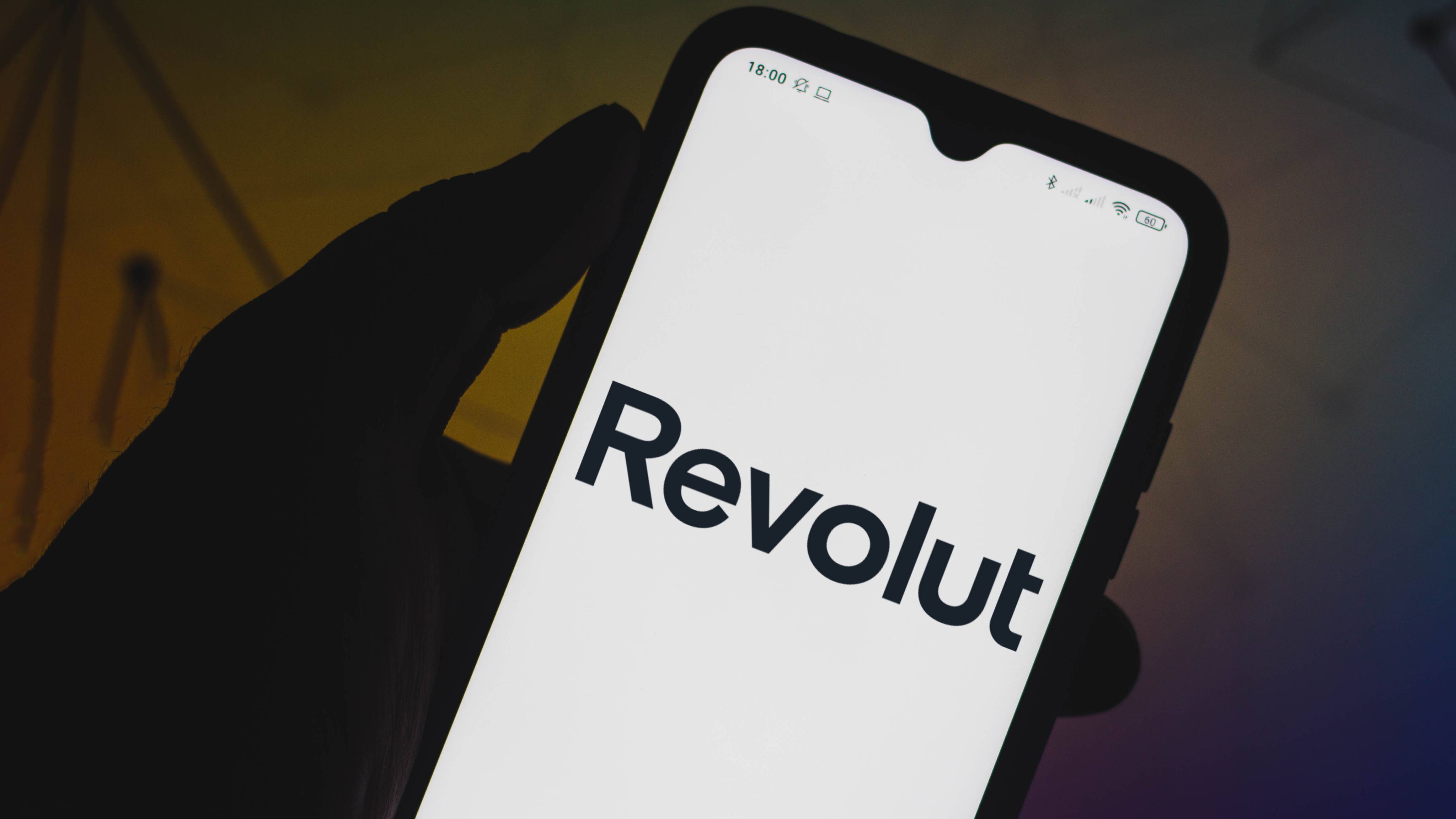 In this photo illustration a Revolut logo seen displayed on