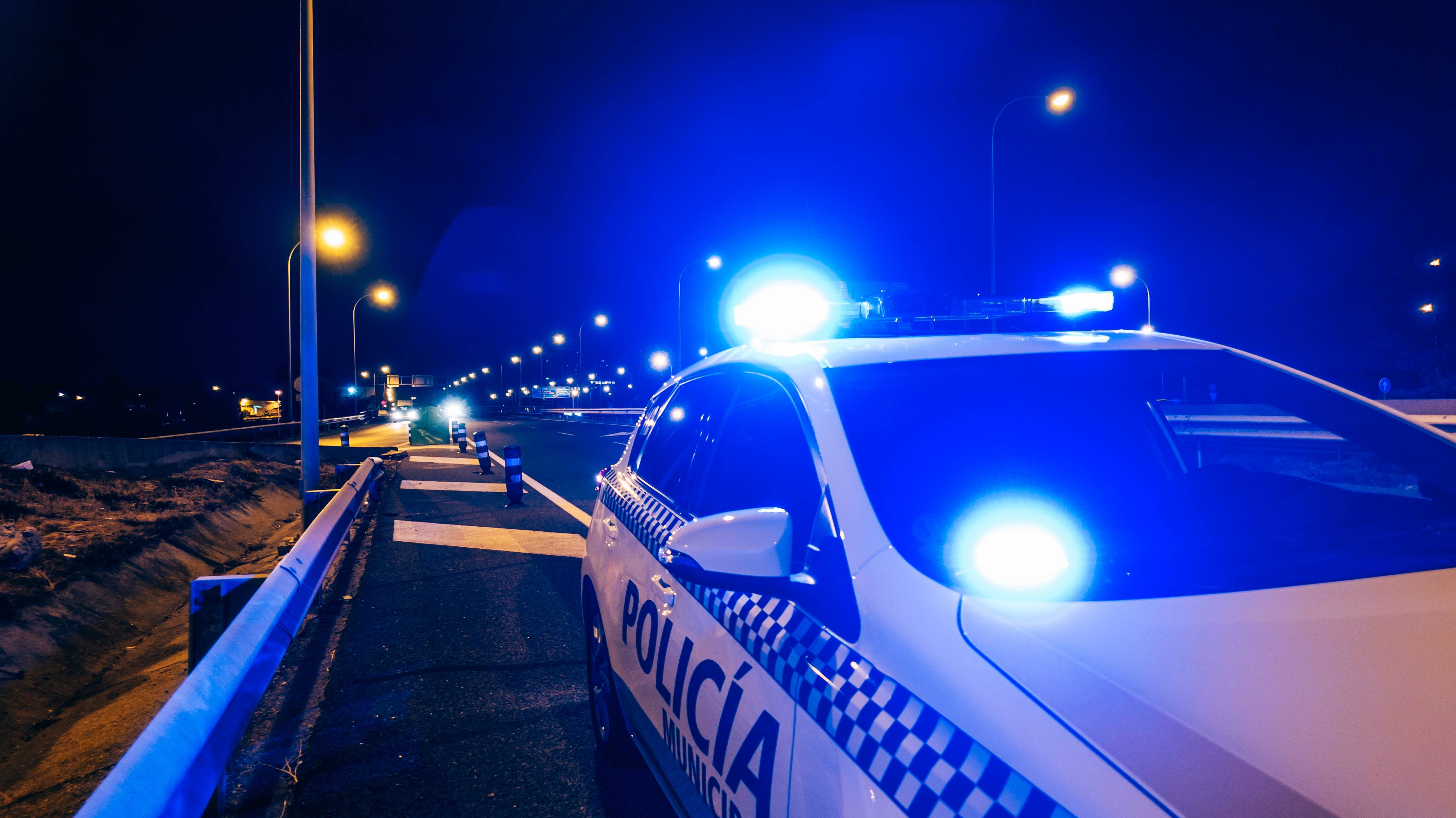 Police car patrol on road of Madrid during night