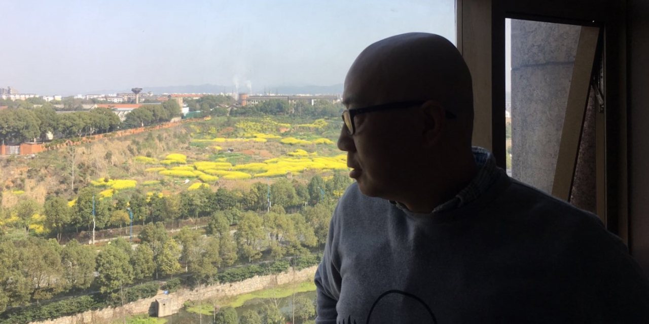 O escritor Han Dong à janela do quarto onde passou 60 dias por causa do coronavírus. A fotografia foi tirada pela sua mulher