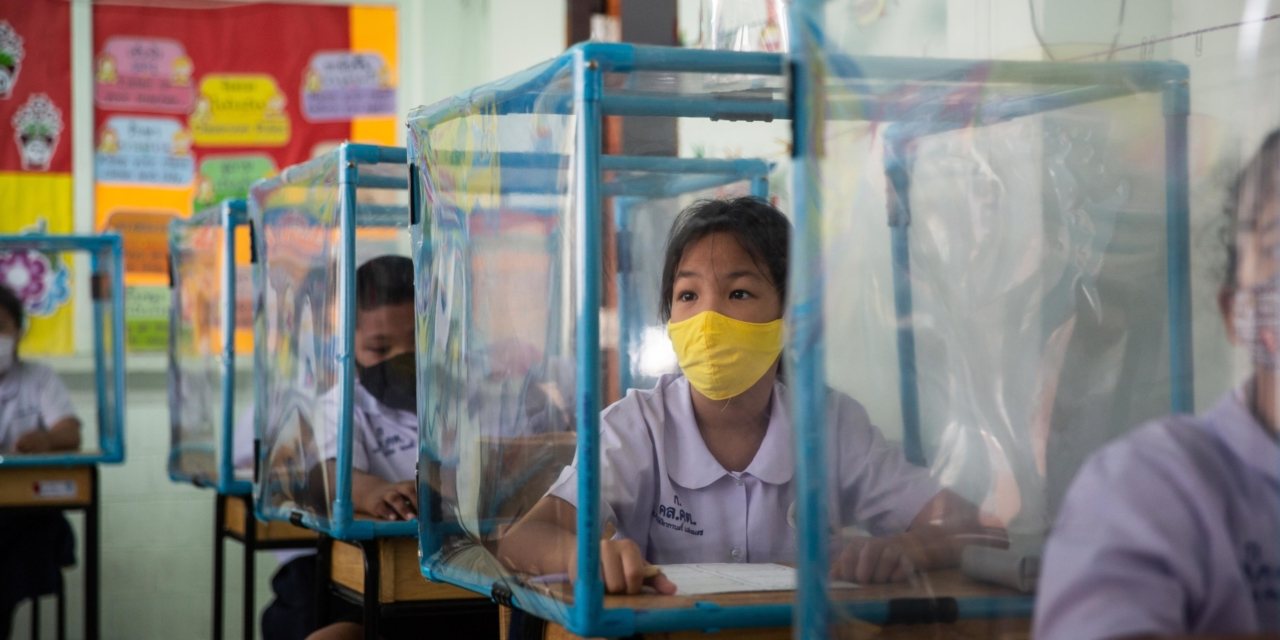 No início de julho, cerca de 250 alunos voltaram à escola tailandesa Wat Khlong Toey e encontraram várias medidas de distanciamento físico, incluindo redomas de plástico sobre as mesas
