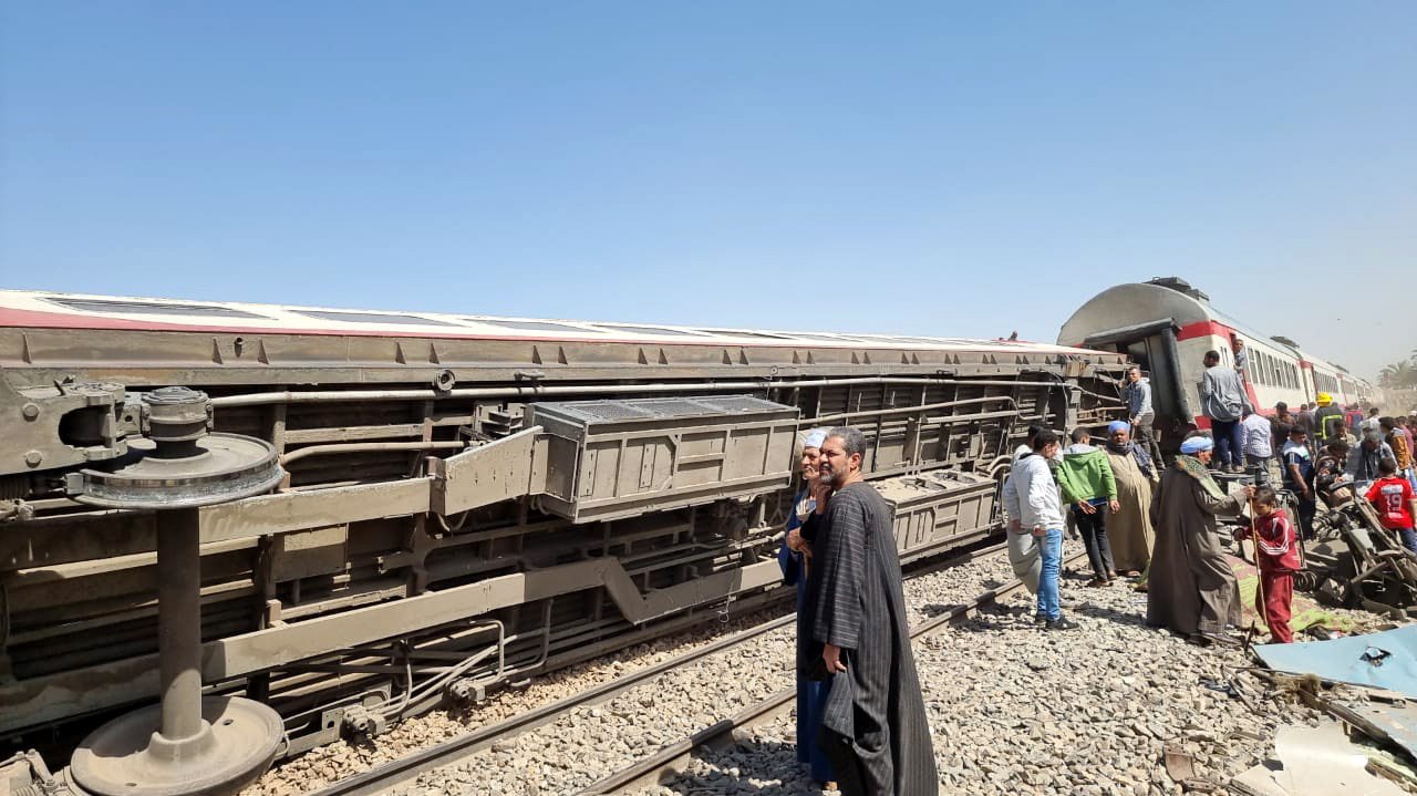 epa09099064 People inspect the scene of a train crash in Sohag province, Egypt, 26 March 2021. At least 32 people were killed and some 66 injured as two passenger trains collided in the Tahta district in Sohag governorate, the Health Ministry announced.  EPA/STRINGER