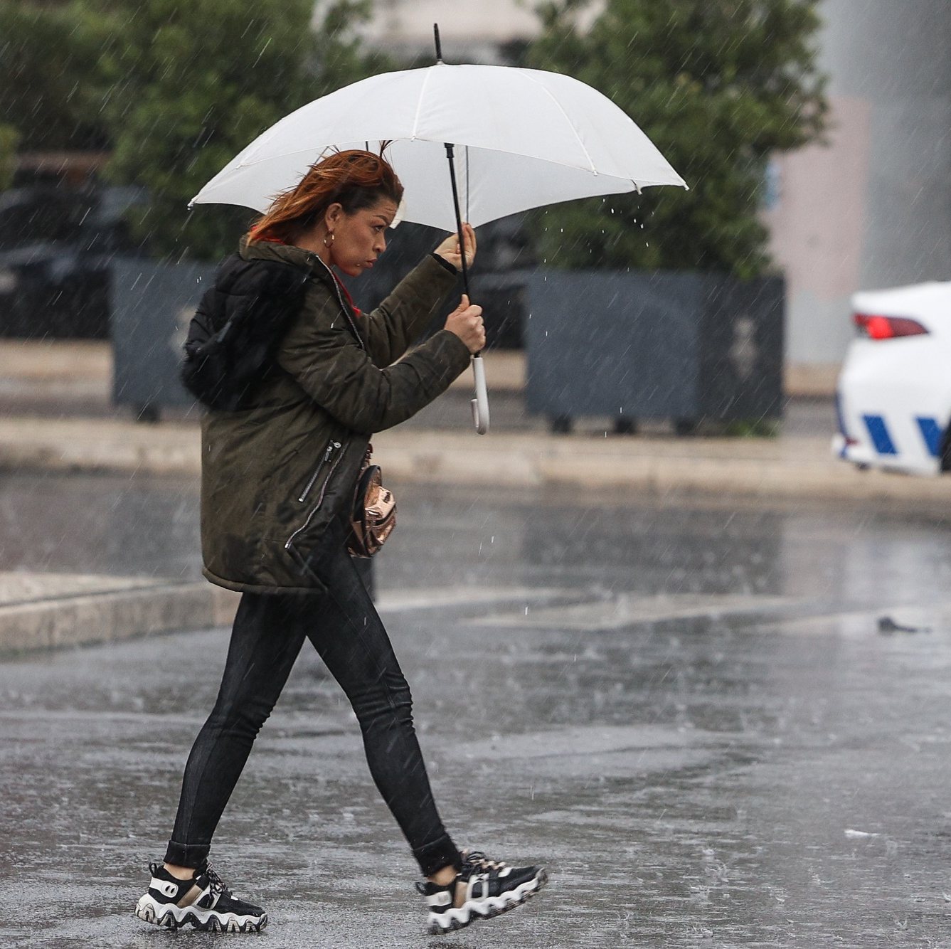 Uma traseunte passa com chapéu de chuva na zona de Algés em Oeiras num dia de temporal, 14 de dezembro de 2022. TIAGO PETINGA/LUSA