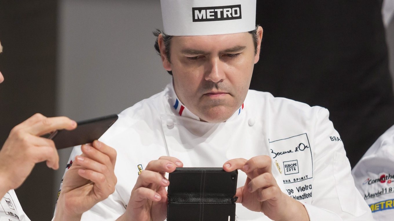epa05297903 Jury members Rasmus Kofoed of Denmark (L) and Serge Vieira of France photograph a dish during the European Final of Bocuse d’Or cuisine contest in Budapest, Hungary, 10 May 2016. There is one chef from each of the twenty European countries to take part in the competition, at the end of which eleven finalist will proceed to compete in the 2017 World Final in Lyon, France. The participants must show their skills by preparing a dish each from sterlet and venison, two meat ingredients used in traditional Hungarian cuisine during the two-day culinary show.  EPA/BALAZS MOHAI HUNGARY OUT