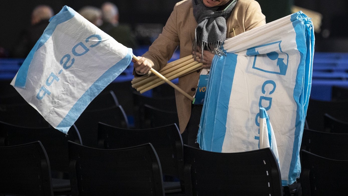 Um membro do CDS-PP coloca bandeiras nas cadeiras durante encerramento do 29.º Congresso do partido, no pavilhão Multiusos de Guimarães, 3 de abril de 2022. JOSÉ COELHO/LUSA
