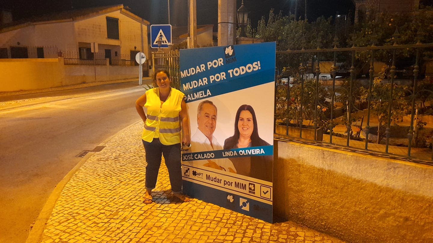 Linda Oliveira numa ação noturna de afixação de cartazes em agosto. Fotografia da página de Facebook da candidata