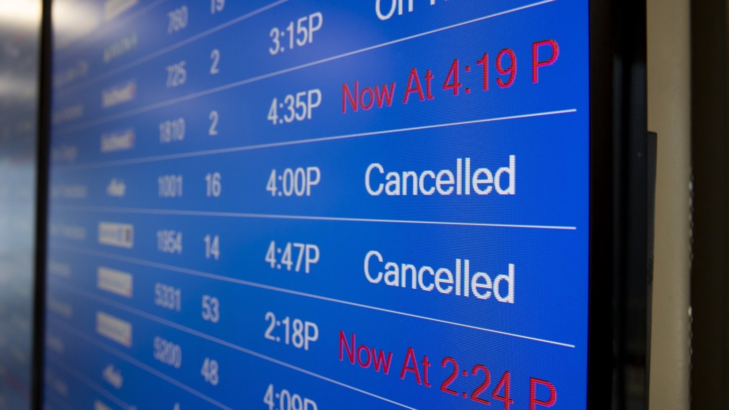 Painel informativo de voos com voos cancelados e atrasados.