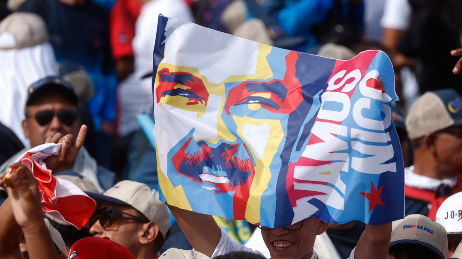 epa11496708 A supporter holds a sign with the image of Venezuelan President and re-election hopeful Nicolas Maduro during a campaign rally in Caracas, Venezuela, 25 July 2024. The Venezuelan presidential elections are scheduled to be held on 28 July 2024.  EPA/HENRY CHIRINOS