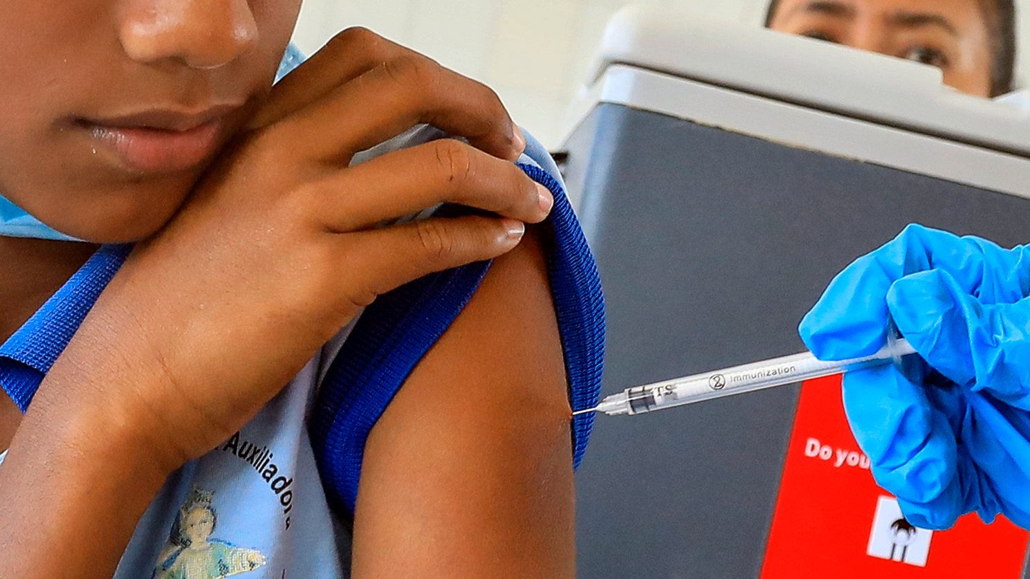Um estudante recebe uma vacina Pfizer contra a Covid-19