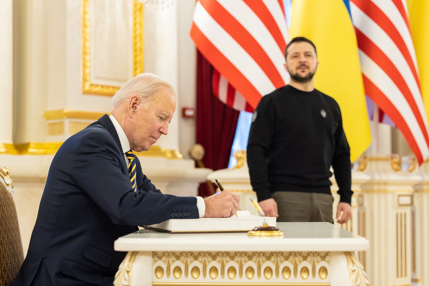 epa10479576 A handout photo made available by the Ukrainian Presidential Press Service on 20 February 2023 shows US President Joe Biden (L) signing in a book as Ukrainian President Volodymyr Zelensky (R) looks on, in Kyiv (Kiev), Ukraine, amid Russia&#039;s invasion. The White House announced on 20 February, that US President Biden met with Ukrainian President Zelensky and his team to extended discussions on US support for Ukraine.  EPA/UKRAINIAN PRESIDENTIAL PRESS SERVICE HANDOUT -- MANDATORY CREDIT: UKRAINIAN PRESIDENTIAL PRESS SERVICE -- HANDOUT EDITORIAL USE ONLY/NO SALES