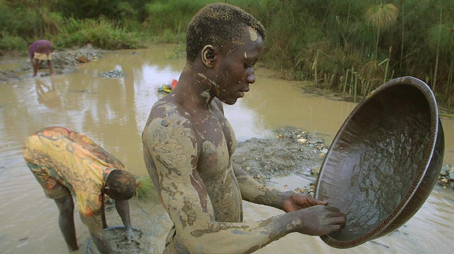A Congolese teenager pans for gold near the town of Nizi in the Ituri region of the Congo, 14 October 2003. The gold trade in the area has diminished due to the ongoing war in the region.
AFP PHOTO/SIMON MAINA
