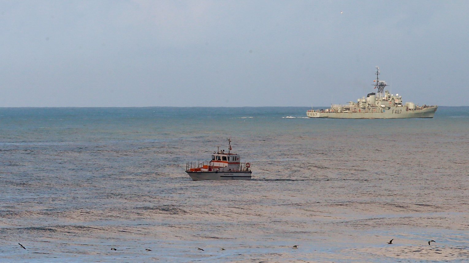 Um barco salva-vidas e a corveta da Marinha NRP João Roby participam nas buscas dos três tripulantes de uma embarcação desaparecida na sexta-feira ao largo na Nazaré, na Praia do Pedrogão em Leiria. PAULO CUNHA/LUSA