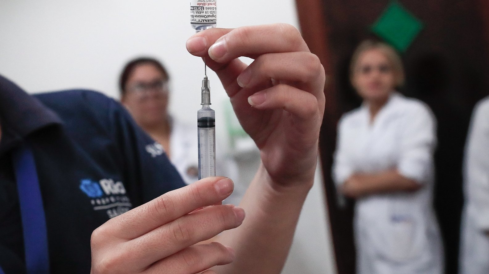 epa10856285 A nurse prepares a dose of the bivalent vaccine against covid-19, in Rio de Janeiro, Brazil, 12 September 2023. In recent weeks there has been a significant increase in confirmed cases of the disease in Rio. The positivity rate of cases grew from 2.5% in July to 18% in the first week of September.  EPA/Andre Coelho