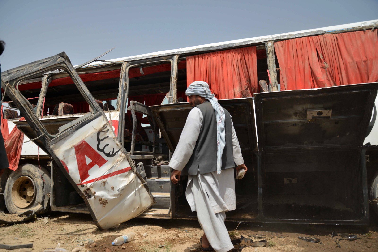 epa10594477 Afghans gather at the scene after a passenger bus overturned in Daman district, Kandahar, Afghanistan, 27 April 2023. At least six people died, and 18 others were injured when the bus overturned on the Kandahar-Kabul highway, Haji Zaid, the spokesman of Kandahar governor of the Taliban government, said.  EPA/STRINGER 14469