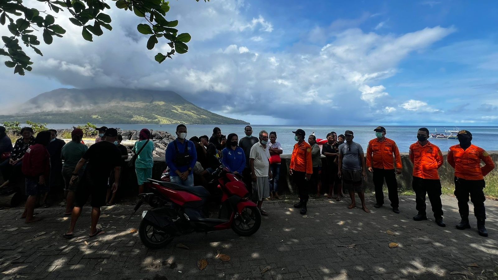 epa11285200 A handout photo made available by National Search and Rescue Agency (BASARNAS) shows people and members of the National Search and Rescue Agency looking at smoke and ash erupting from Mount Ruang, as seen from Sitaro, Indonesia, 17 April 2024. The Center for Volcanology and Geological Disaster Mitigation (PVMBG) of the Ministry of Energy and Mineral Resources reported that Mount Ruang in the Sitaro Islands Regency, North Sulawesi, erupted on 16 April night. As a result of the eruption of Mount Ruang, 272 families, or around 828 people, were evacuated.  EPA/BASARNAS HANDOUT  HANDOUT EDITORIAL USE ONLY/NO SALES HANDOUT EDITORIAL USE ONLY/NO SALES