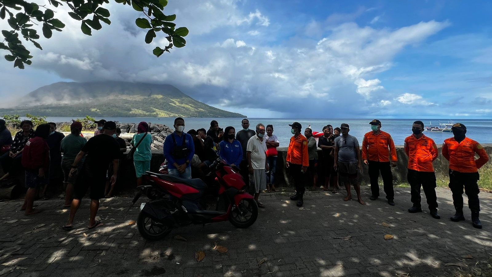 epa11285200 A handout photo made available by National Search and Rescue Agency (BASARNAS) shows people and members of the National Search and Rescue Agency looking at smoke and ash erupting from Mount Ruang, as seen from Sitaro, Indonesia, 17 April 2024. The Center for Volcanology and Geological Disaster Mitigation (PVMBG) of the Ministry of Energy and Mineral Resources reported that Mount Ruang in the Sitaro Islands Regency, North Sulawesi, erupted on 16 April night. As a result of the eruption of Mount Ruang, 272 families, or around 828 people, were evacuated.  EPA/BASARNAS HANDOUT  HANDOUT EDITORIAL USE ONLY/NO SALES HANDOUT EDITORIAL USE ONLY/NO SALES