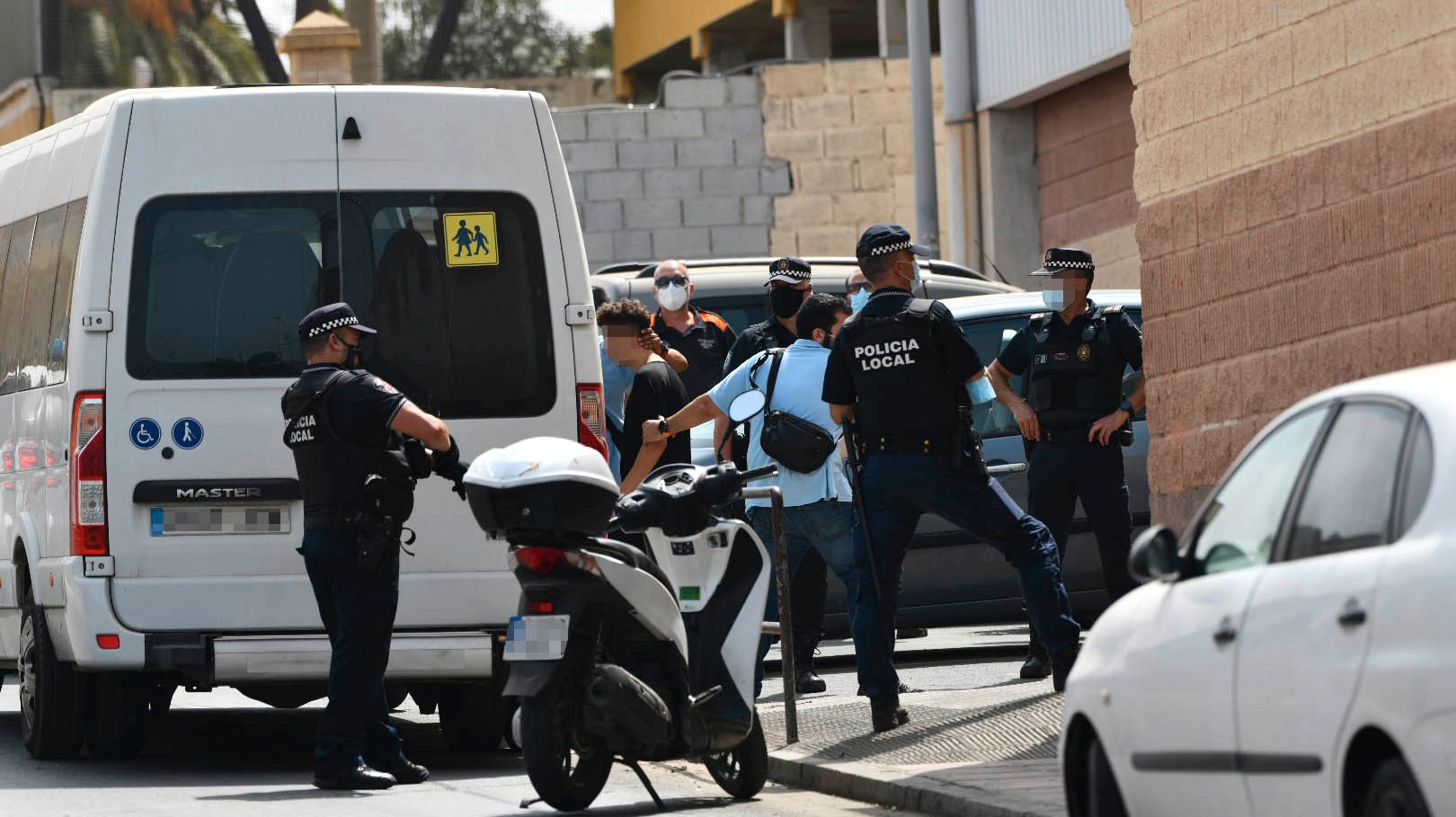 Vários agentes e veículos da polícia local de Ceuta acompanham menores para uma carrinha, esta sexta-feira
