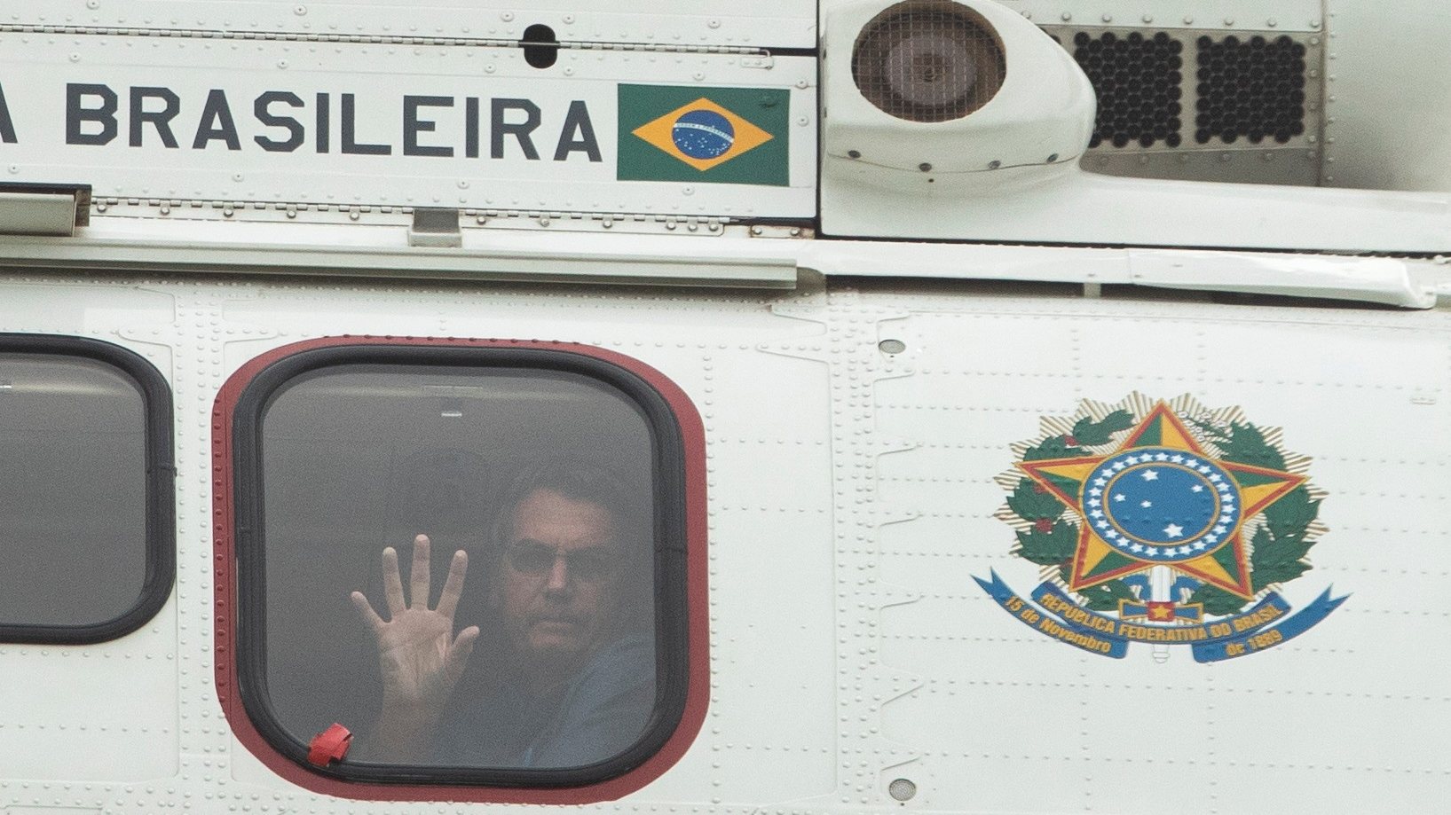 epa09172480 Brazilian President Jair Bolsonaro waves from a helicopter to supporters during a support rally during the International Workers Day commemoration in Brasilia, Brazil, 01 May 2021.  EPA/Joedson Alves