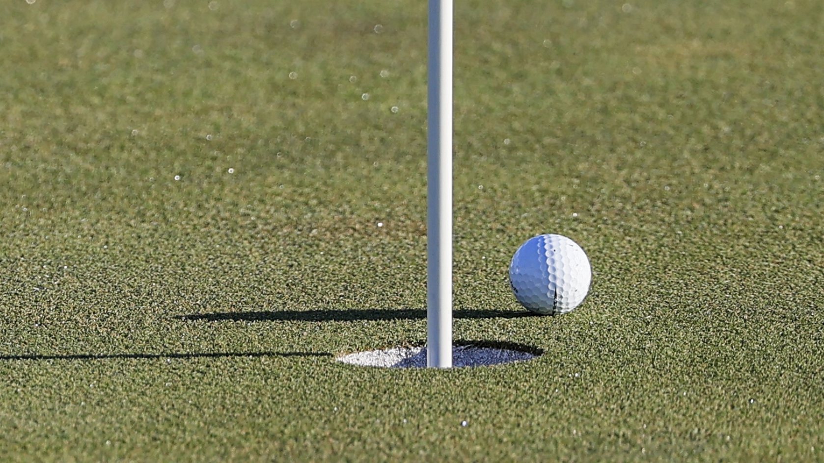 epa09487843 The ball lies next to the cup on the fourth green after European team member Jon Rahm of Spain made his chip shot during Foursomes matches on the second day of the pandemic-delayed 2020 Ryder Cup golf tournament at the Whistling Straits golf course in Kohler, Wisconsin, USA, 24 September 2021. Competition for the 43rd Ryder Cup between the US and Europe began 24 September 2021.  EPA/TANNEN MAURY