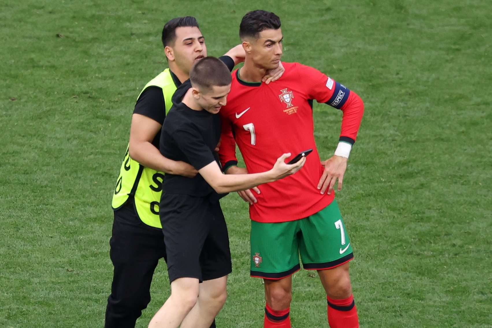 epa11430995 A pitch invader attempts to take a picture with Cristiano Ronaldo of Portugal during the UEFA EURO 2024 group F soccer match between Turkey and Portugal, in Dortmund, Germany, 22 June 2024.  EPA/CHRISTOPHER NEUNDORF