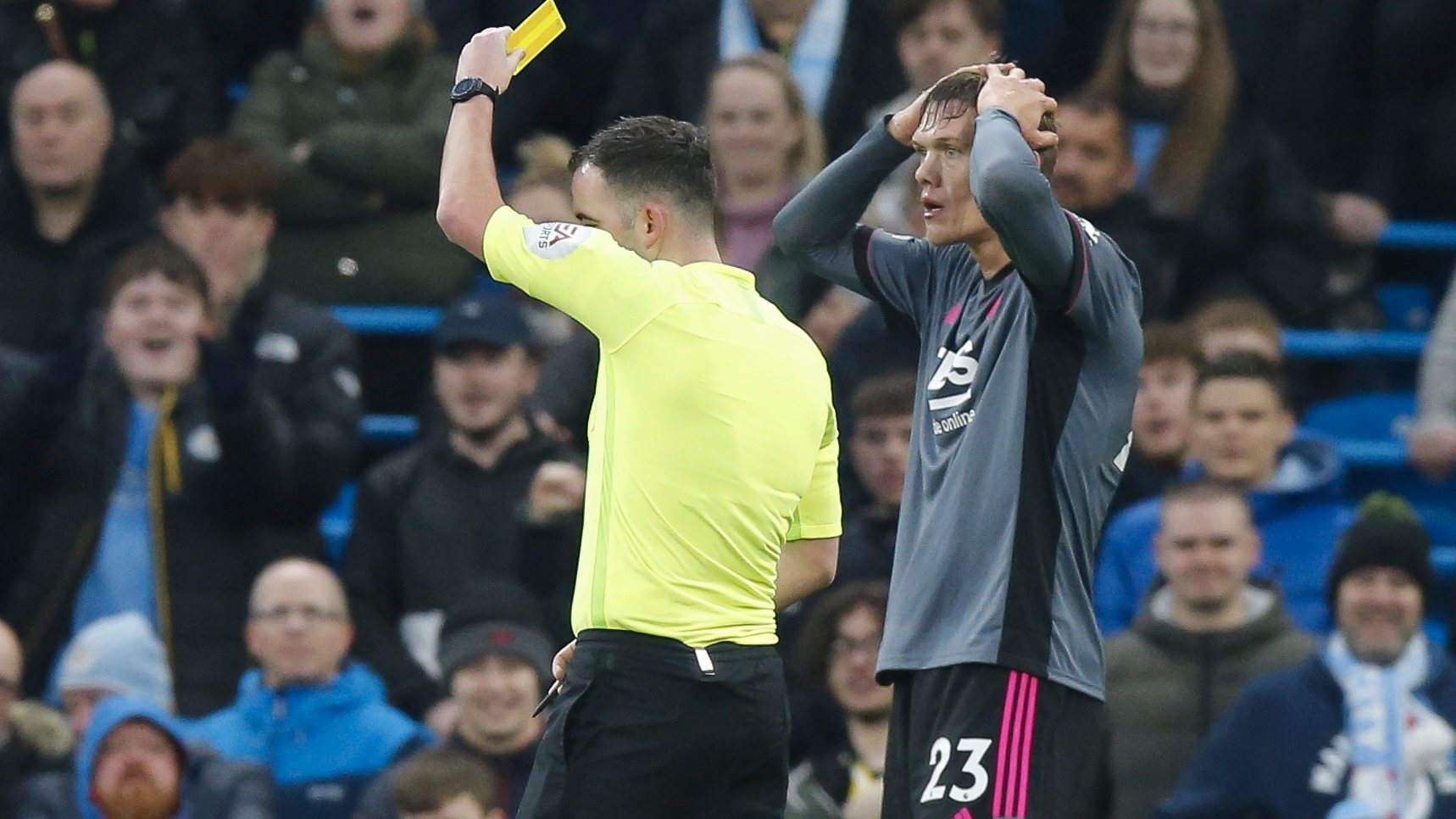 Árbitro Chris Kavanagh a mostrar cartão amarelo a Jannik Vestergaard, jogador do Leicester