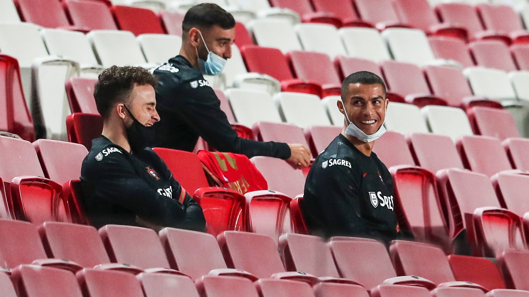 epa08814762 Portugal national team players Cristiano Ronaldo (R), Diogo Jota and Bruno Fernandes laugh in the stands prior to the friendly soccer match between Portugal and Andorra, held at Luz stadium in Lisbon, Portugal, 11 November 2020.  EPA/JOSE SENA GOULAO