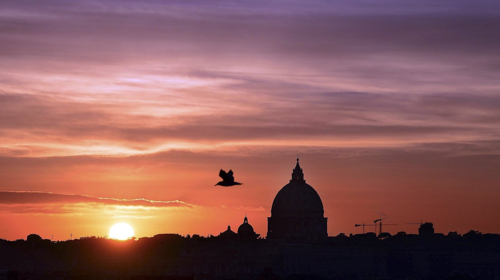 epa05050282 A picture made available on 01 December 2015 shows a view of the colorful sky as the sun sets behind Saint Peter&#039;s Basilica in Rome, late  30 November 2015. The Jubilee dedicated to mercy was announced by Pope Francis on 13 March 2015. It will be open from 08 December 2015 to 20 November 2016.  EPA/CLAUDIO ONORATI