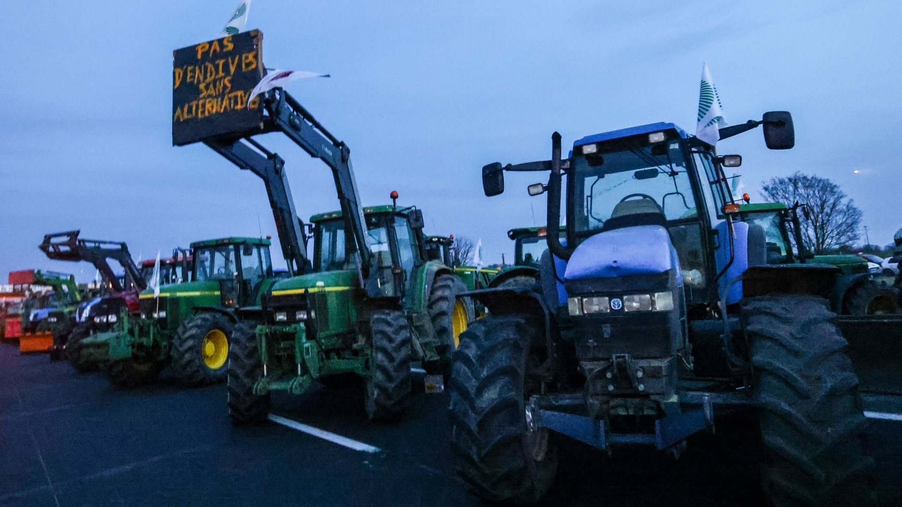 epa11112979 Tractors park at blockade point on the A4 highway at Jossigny, near of Paris, France, 29 January 2024. The placard reads &#039;No endives without alternative.&#039; French farmers continue their protests with road blockades and demonstrations in front of state buildings awaiting a response from the government to their request for &#039;immediate&#039; aid of several hundred million euros. On 23 January, the EU Agriculture and Fisheries Council highlighted the importance of providing the conditions necessary to enable EU farmers to ensure food security sustainably and profitably, as well as ensuring a fair income for farmers.  EPA/MOHAMMED BADRA