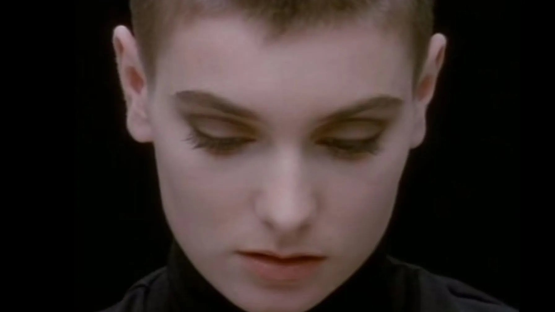 O grande plano de Sinéad O'Connor, de cabelo rapado e gola alta preta, a imagem do vídeo realizado por John Maybury e que é hoje um clássico