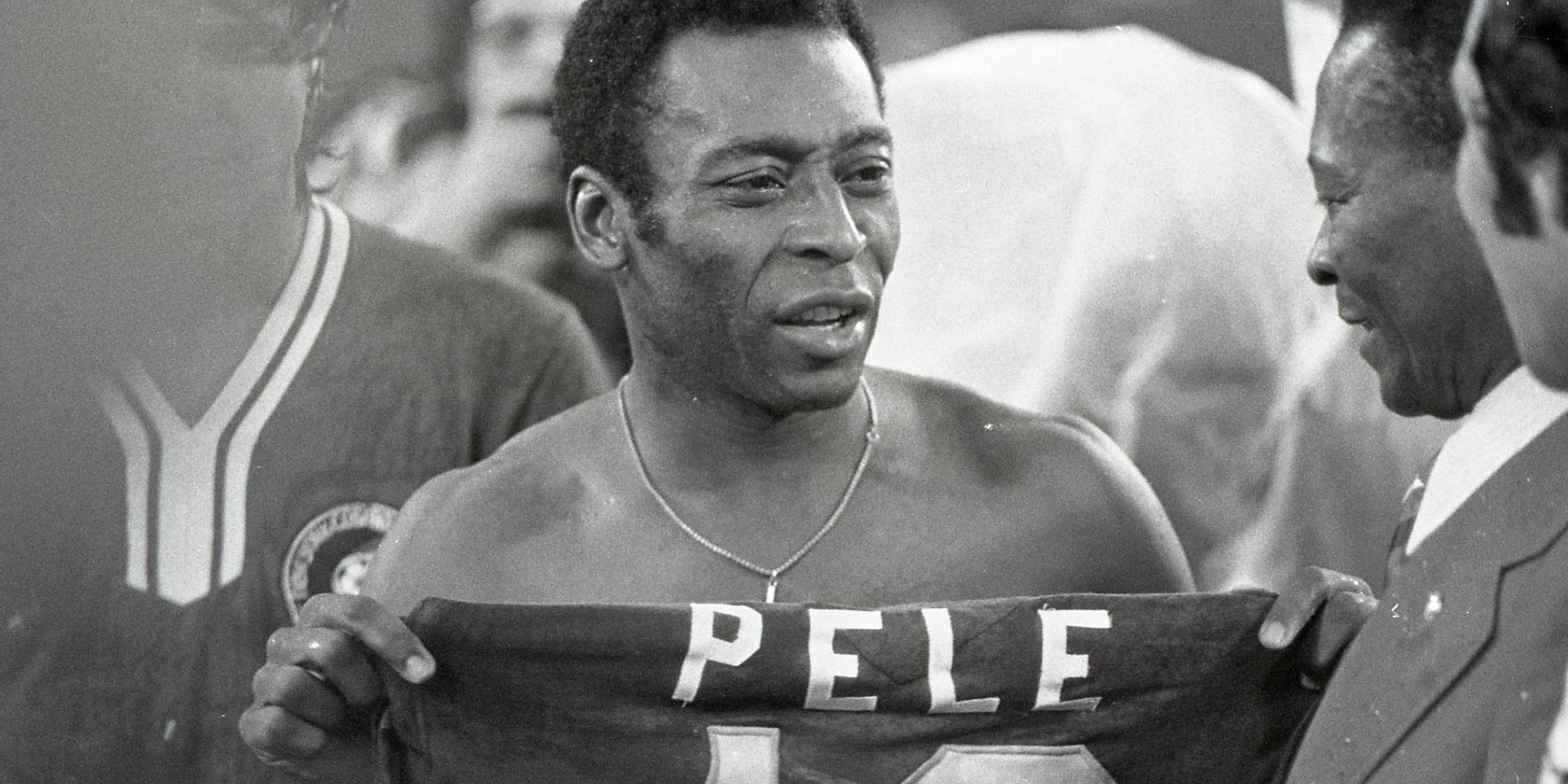 Soccer player Pele hands jersey to his father at his last professional game in 1977