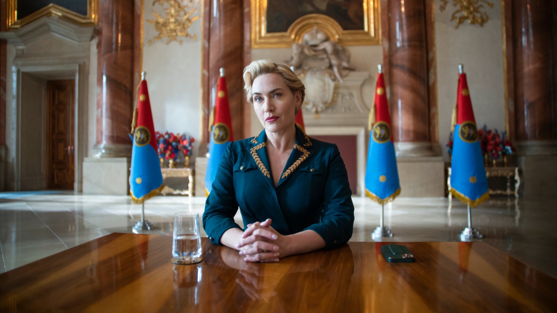 Estamos algures num país fictício da Europa Central, onde uma lunática chanceler (Kate Winslet) lidera um regime autoritário enquanto se dirige aos súbditos como “meus amores”, apesar de os vigiar e de reinar um ambiente de medo e sanções