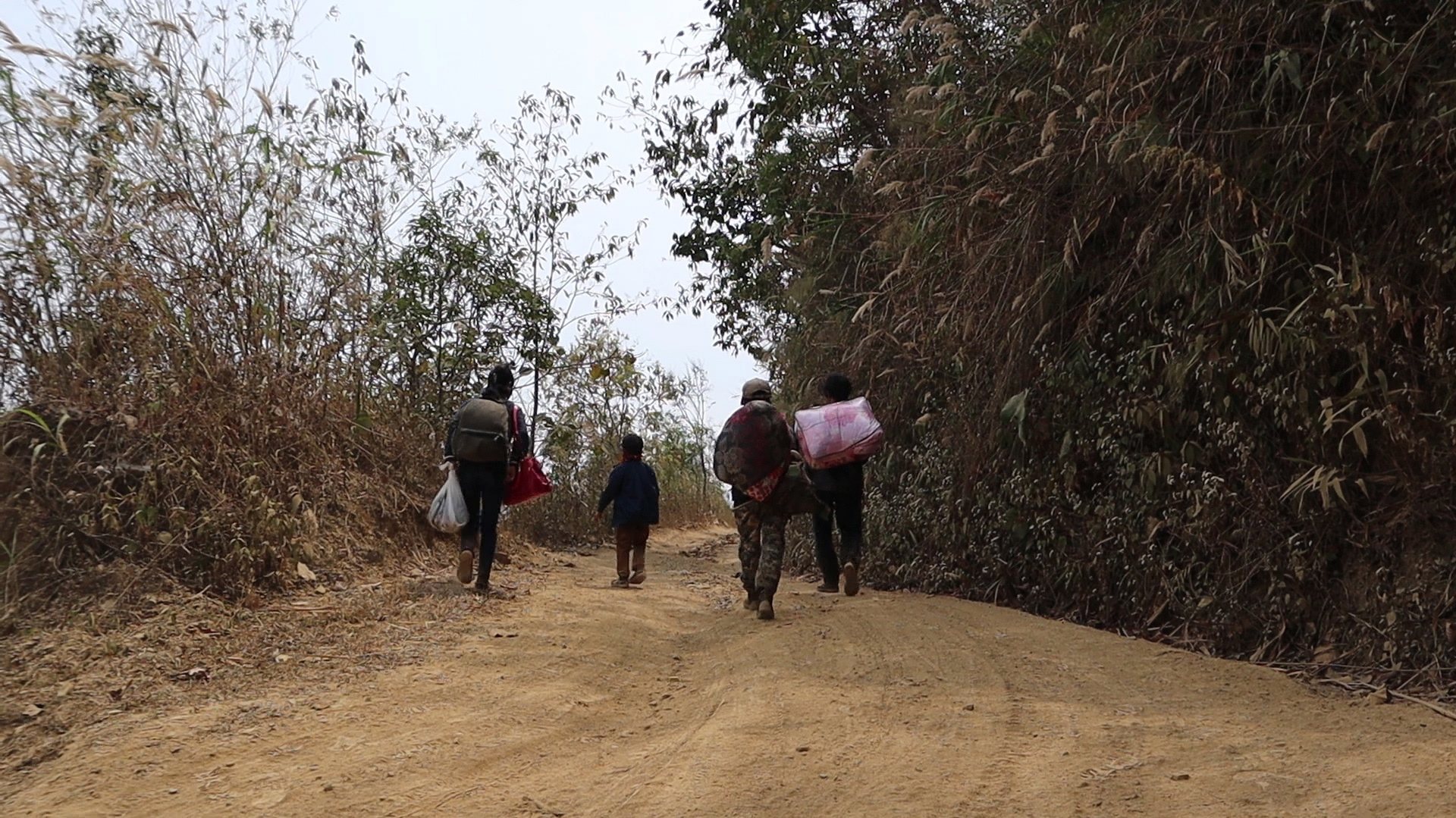 epa09098337 A small group of refugees from Myanmar carrying a few belongings after they crossed the border near a small village at an undisclosed location at the border between India and Myanmar to seek shelter in the area of Mizoram, India, 20 March 2021 (issued 26 March 2021). Many people from Myanmar crossed the border to India after the February 2021 military coup. Against all orders by the Indian government, villagers along the border and members of the Young Mizo Association (YMA), a non-governmental organization of India&#039;s northeastern state of Mizoram, are playing the role of a &#039;Good Samaritan&#039; by sheltering Myanmarese seeking refuge in India. Among the refugees are many firemen and police personnel, who defied the army&#039;s forcefully order to stop the civil disobedience movement (CDM) protest across the Chin Hills state of Myanmar.  EPA/SANGZUALA HMAR