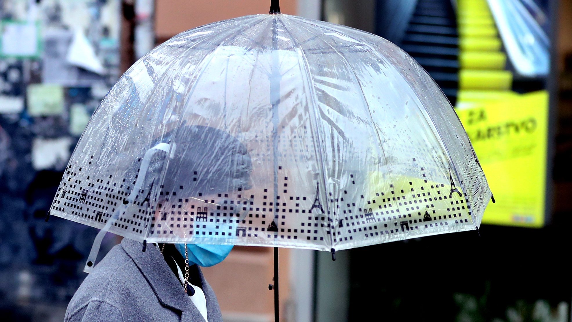 epa08830893 A woman wearing face mask walks holding an umbrella during rain in Sarajevo, Bosnia and Herzegovina, 20 November 2020.  EPA/FEHIM DEMIR