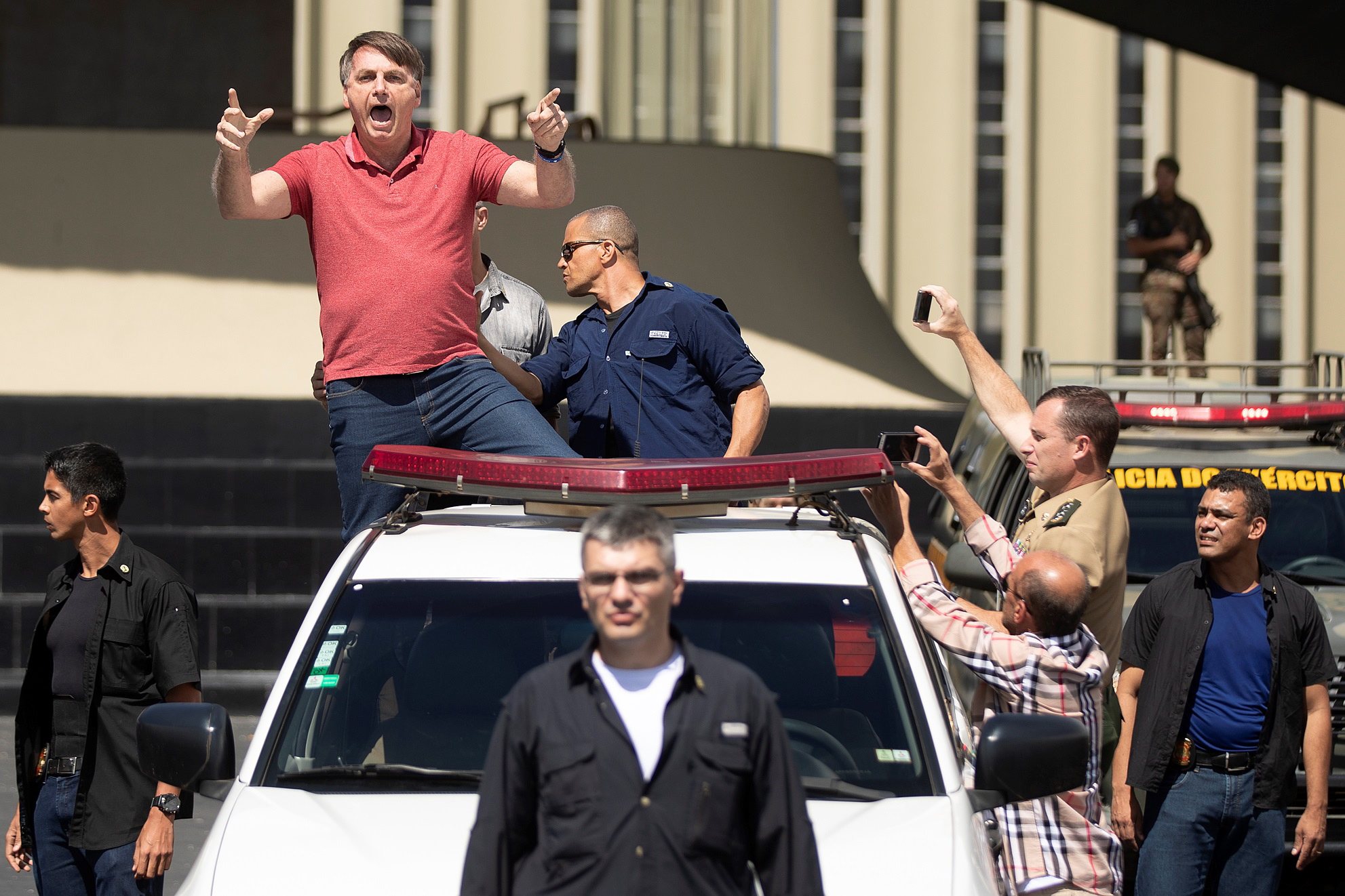 epa08372104 Brazilian President Jair Bolsonaro waves to supporters during a rally in Brasilia, Brazil, 19 April 2020. Dozens of Brazilian gathered to show their support to Bolsonaro despite the coronavirus situation which, to date, reported 36,599 cases positives of COVID-19 in the country.  EPA/Joedson Alves
