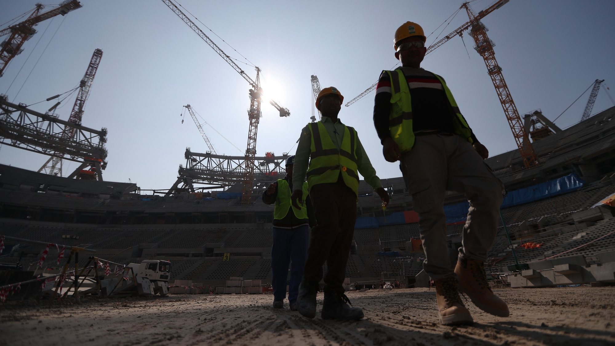 epa08083064 Construction workers at Lusail  Stadium during a media tour in Doha, Qatar, 20 December 2019. Lusail Stadium is one of the eight stadiums build for the FIFA World Cup 2022 in Qatar.  EPA/ALI HAIDER