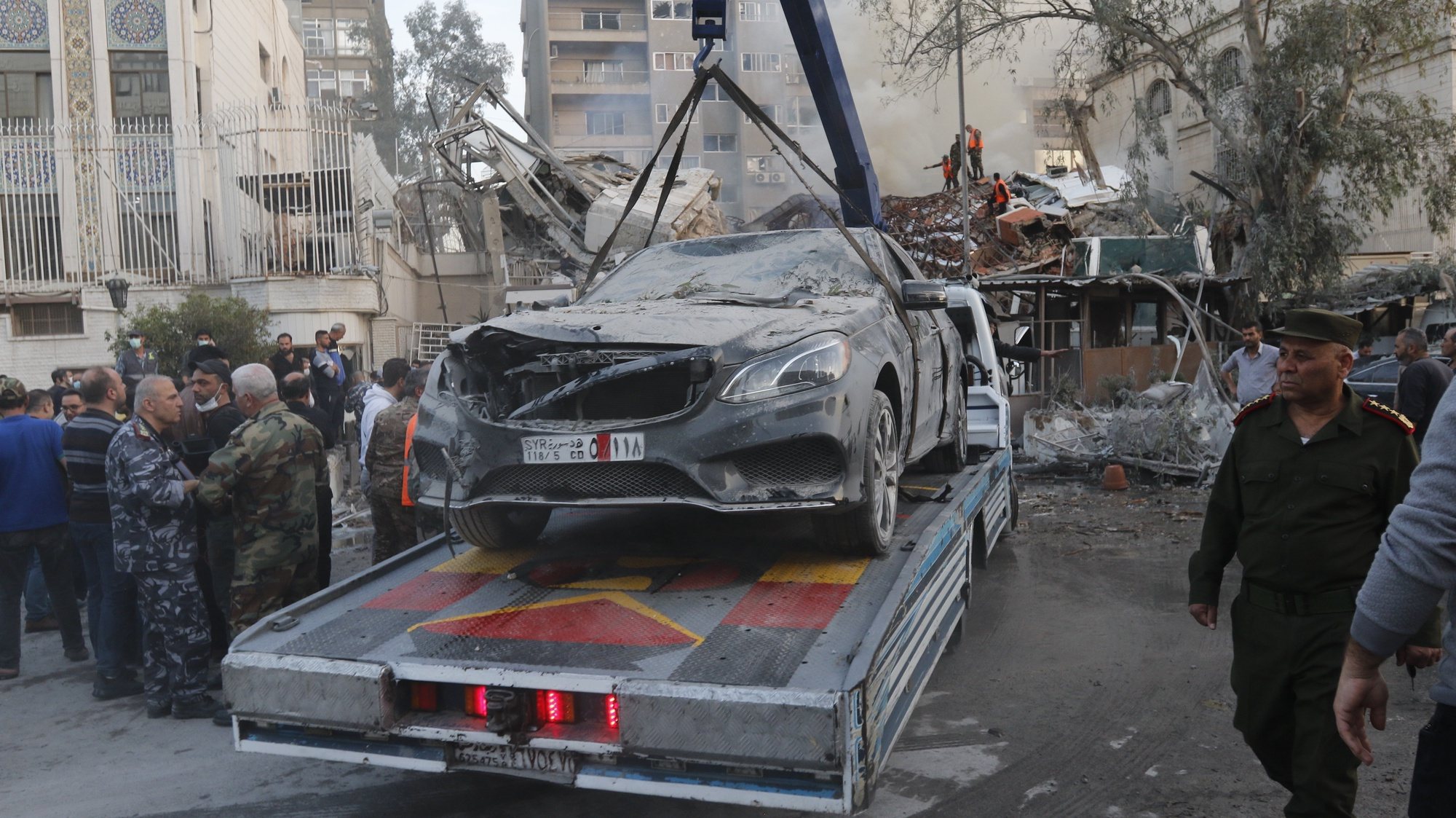 epa11254843 A damaged vehicle is removed following an airstrike next to the Iranian consulate in Damascus, Syria, 01 April 2024. According to the Syrian Arab News Agency SANA, Israel on 01 April launched an airstrike targeting the Iranian consulate building in Damascus. The consulate was damaged while the building next to it was destroyed.  EPA/YOUSSEF DAFAWWI