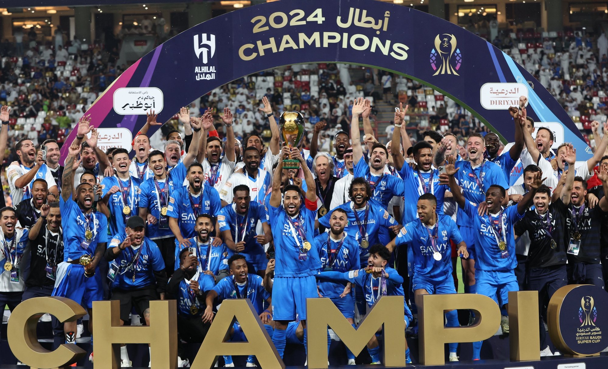epa11273722 Salem Al-Dawsari (C) of Al-Hilal lifts the trophy on the podium after winning the Saudi Super Cup final between Al-Ittihad and Al-Hilal in Abu Dhabi, United Arab Emirates, 11 April 2024.  EPA/ALI HAIDER