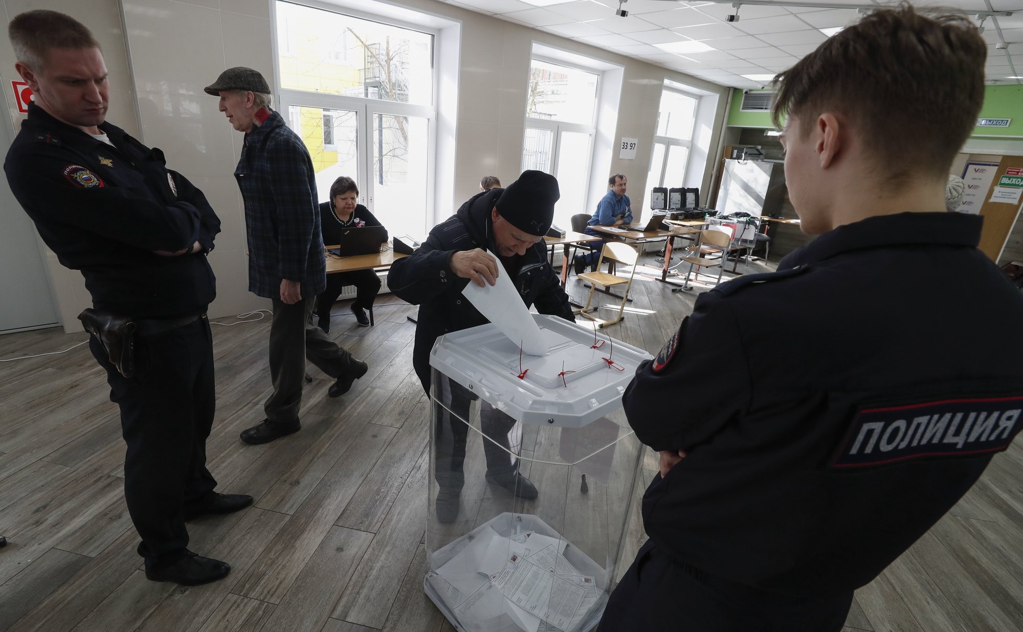 epaselect epa11223720 Russian policemen guard near ballot box as an elderly man casts his ballot during presidential elections in Moscow, Russia, 16 March 2024. The Federation Council has scheduled presidential elections for March 17, 2024. Voting will last three days: March 15, 16 and 17. Four candidates registered by the Central Election Commission of the Russian Federation are vying for the post of head of state: Leonid Slutsky, Nikolai Kharitonov, Vladislav Davankov and Vladimir Putin.  EPA/MAXIM SHIPENKOV