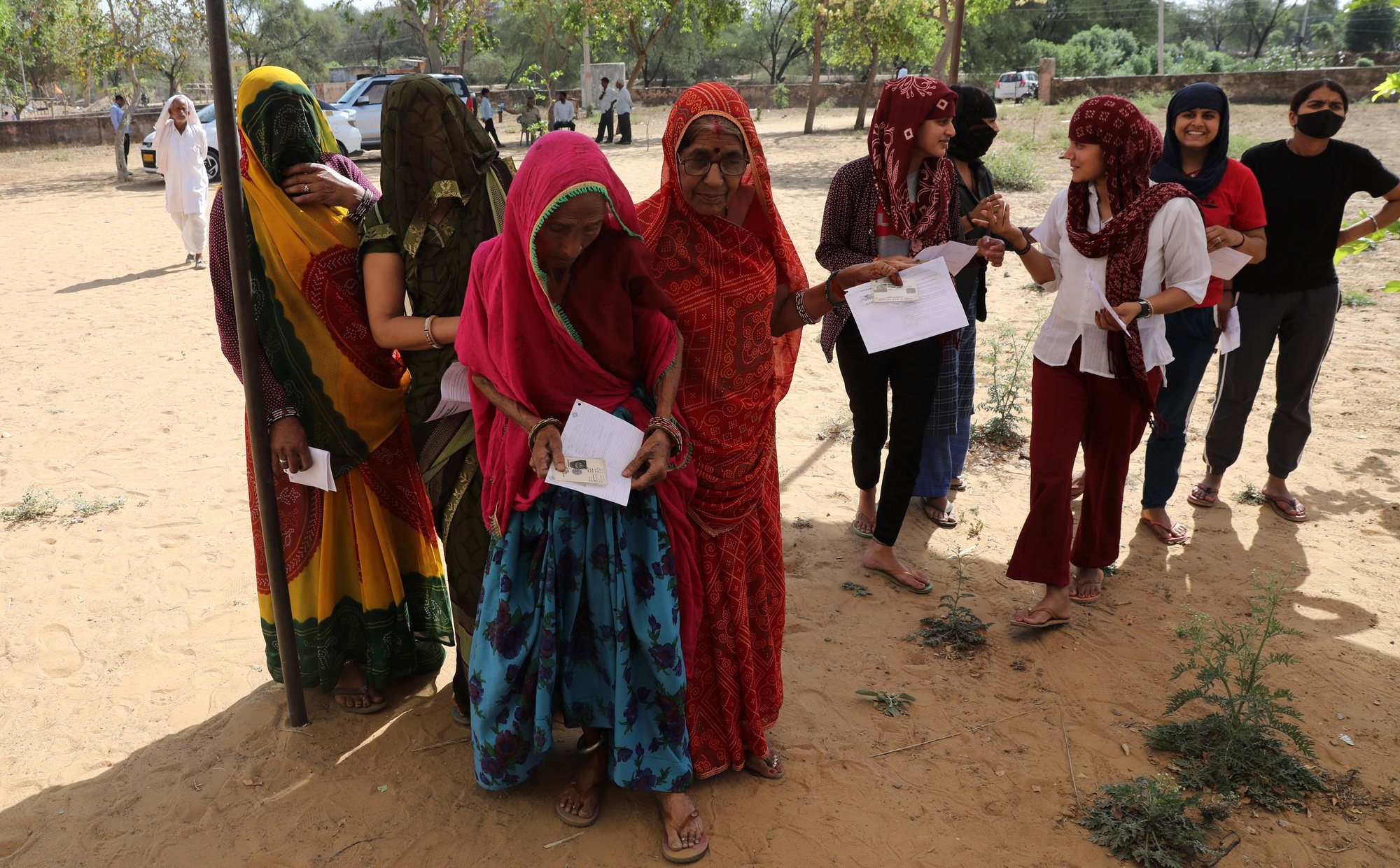 epa11287796 Indian women stand and wait at a polling station to cast their vote in the first phase of the general elections, in Shahpura village, on the outskirts of Jaipur, Rajasthan, India, 19 April 2024. The Indian general elections will be held over seven phases between 19 April and 01 June 2024 with the results being announced on 04 June for the 545-member lower house of parliament, or Lok Sabha. The elections are held every five years, and about 968 million people are eligible to vote.  EPA/RAJAT GUPTA