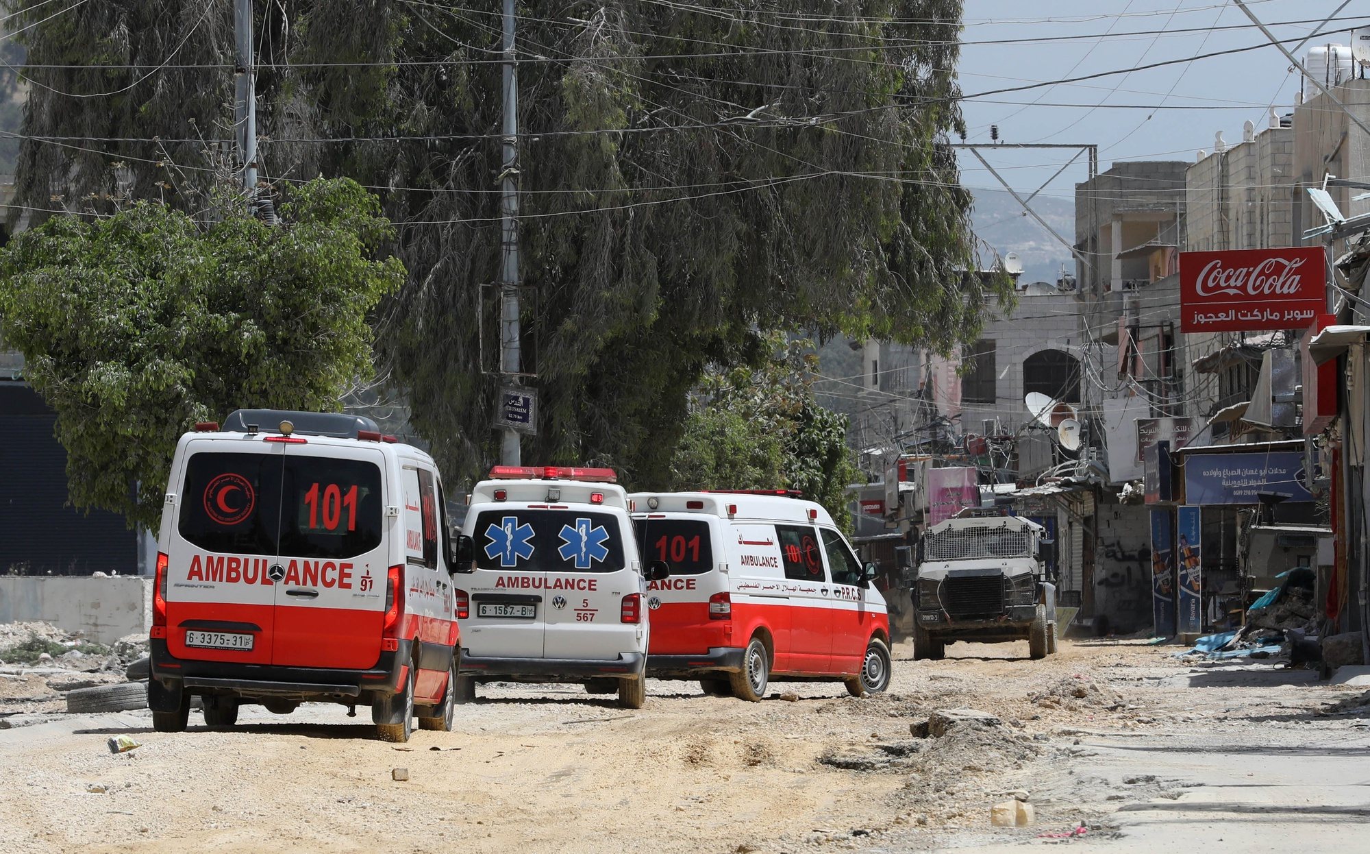 epaselect epa11290385 Palestinian ambulances wait for permission to cross during an Israeli army operation in the West Bank refugee camp of Nour Shams, 20 April 2024. According to an Israeli army spokesperson, the Israeli military has been carrying out a raid on Nur Shams for more than 40 hours. Since the beginning of the activity, eight soldiers were injured with minor and moderate injuries, and several Palestinians were killed and injured.  EPA/STR STRINGER