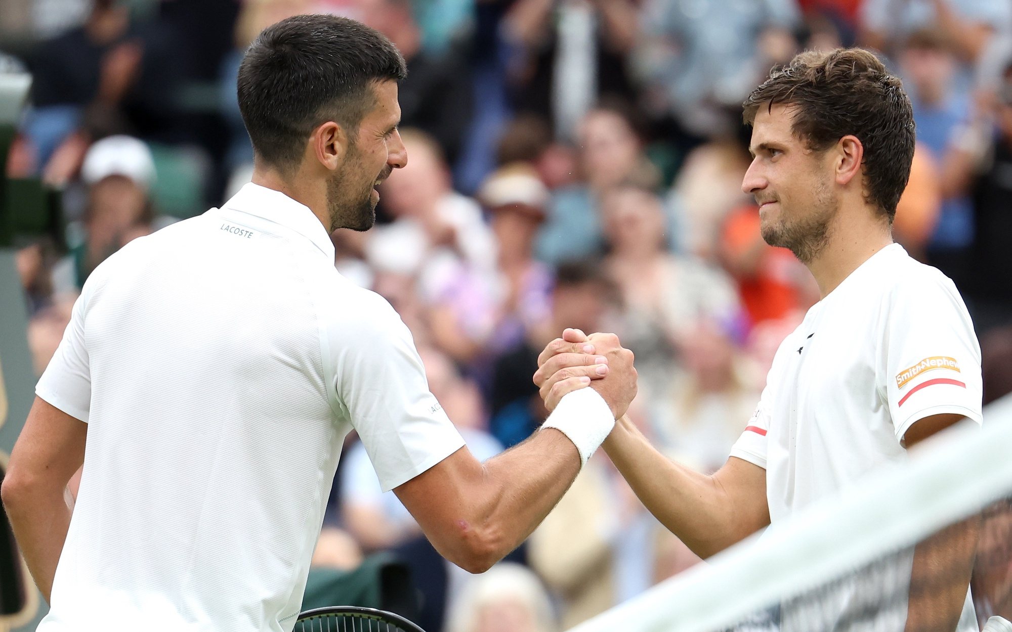 epa11452859 Novak Djokovic (L) of Serbia is congratulated at the net by Vit Kopriva of the Czech Republic after winning their Men&#039;s 1st round match at the Wimbledon Championships, Wimbledon, Britain, 02 July 2024. Djokovic won in three sets.  EPA/NEIL HALL  EDITORIAL USE ONLY