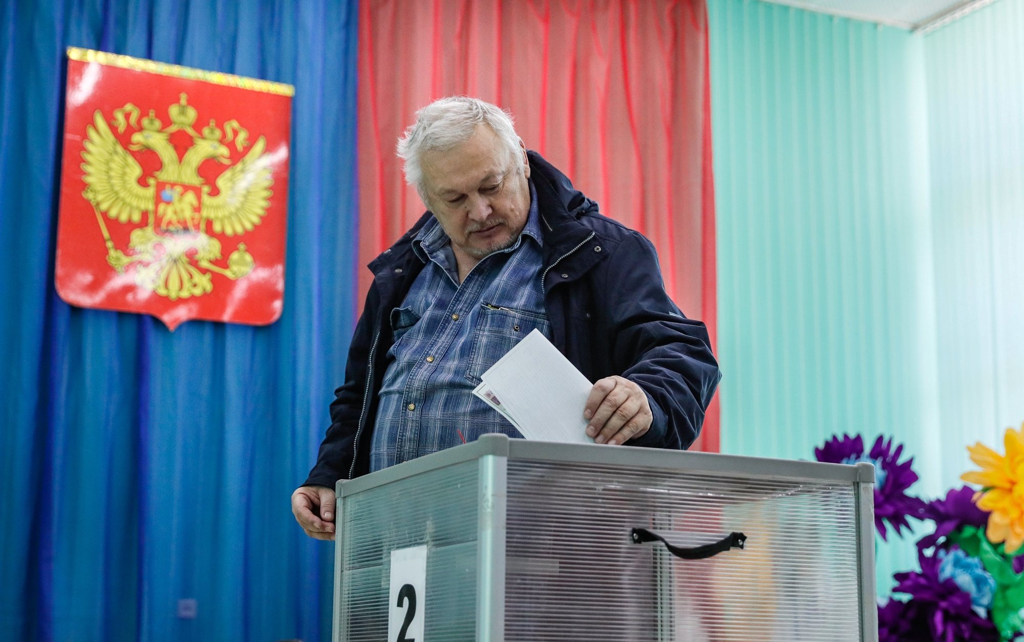 epa11225716 A Russian man casts his ballot during the presidential elections at a polling station in Baikonur, Kazakhstan, 17 March 2024. The Federation Council has scheduled presidential elections for 17 March 2024. Voting will last three days: March 15, 16 and 17. Four candidates registered by the Central Election Commission of the Russian Federation are vying for the post of head of state: Leonid Slutsky, Nikolai Kharitonov, Vladislav Davankov and Vladimir Putin. Baikonur is the location of the Russian leased Baikonur cosmodrome.  EPA/YURI KOCHETKOV