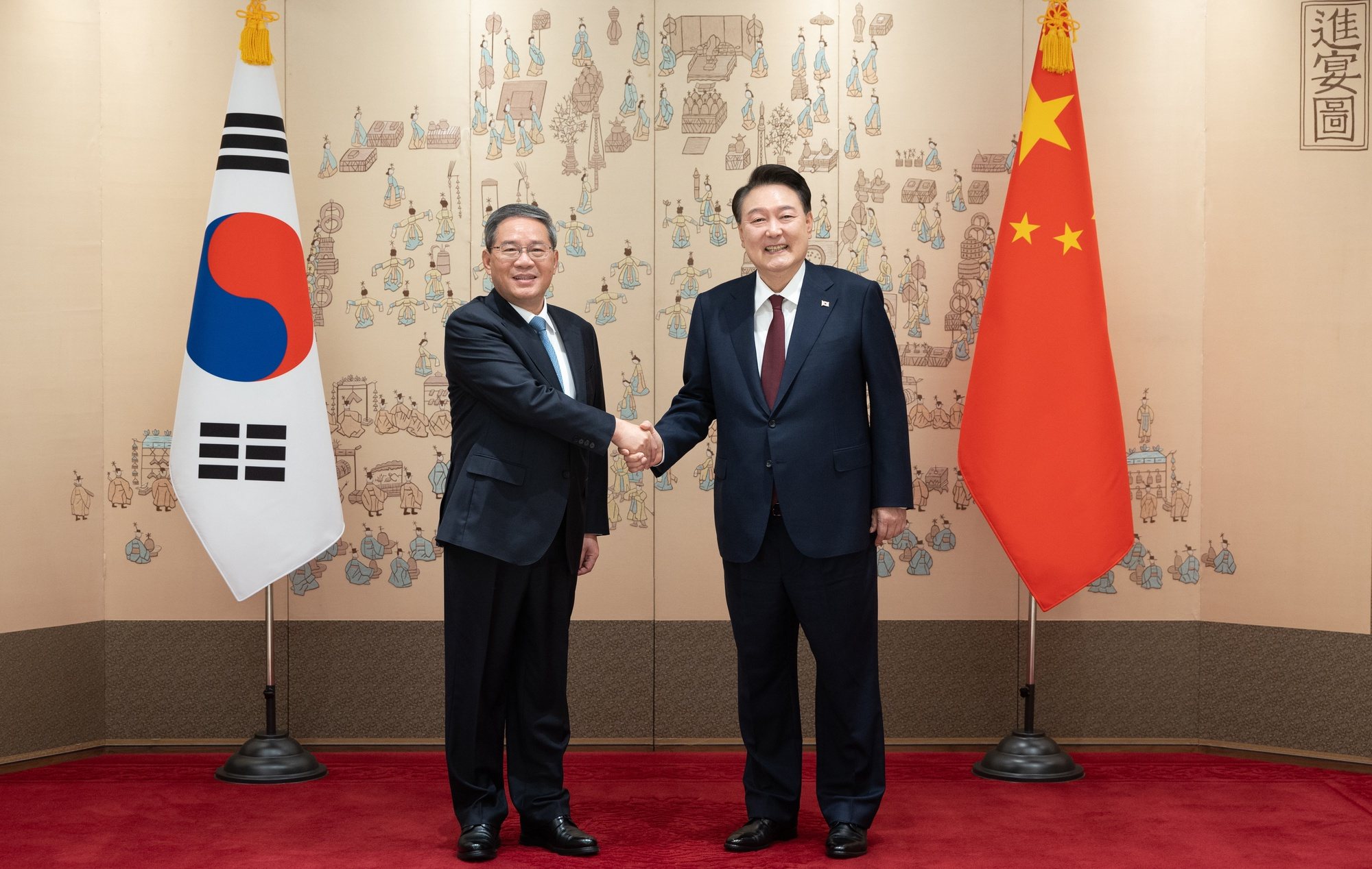 epa11370620 South Korean President Yoon Suk Yeol (R) shakes hands with Chinese Premier Li Qiang (L) during a meeting at the Presidential Office in Seoul, South Korea, 26 May 2024. South Korean President Yoon Suk Yeol is holding bilateral meetings with Chinese Premier Li Qiang and Japanese Prime Minister Fumio Kishida on 26 May, before the three leaders hold a trilateral summit in Seoul on 27 May for the first time since 2019.  EPA/YONHAP / POOL SOUTH KOREA OUT