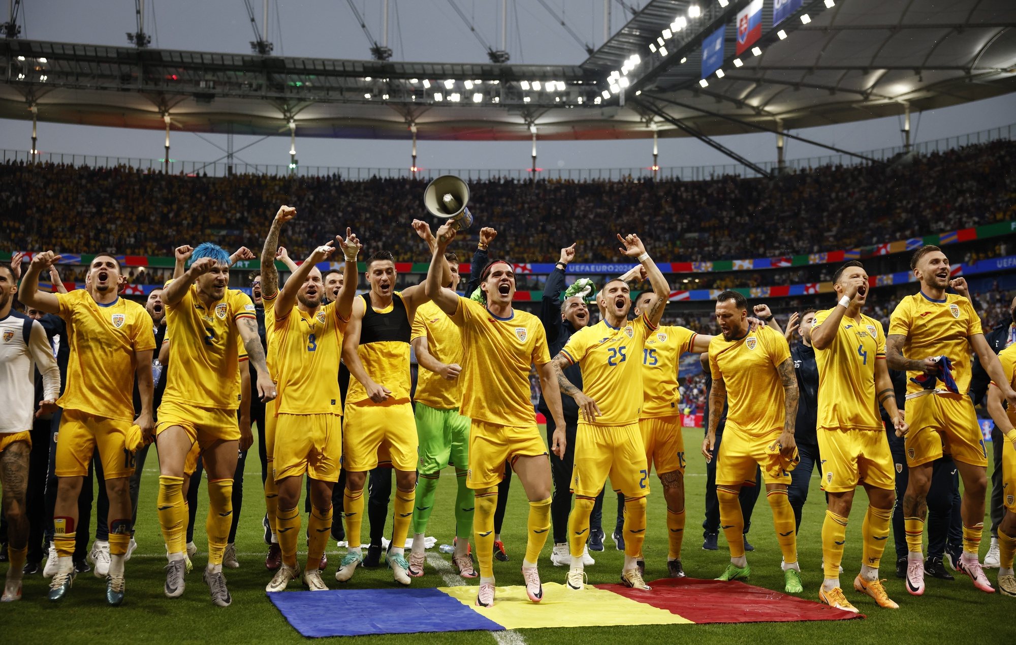 epa11439860 Players of Romania celebrate after the UEFA EURO 2024 group E soccer match between Slovakia and Romania, in Frankfurt Main, Germany, 26 June 2024.  EPA/YOAN VALAT