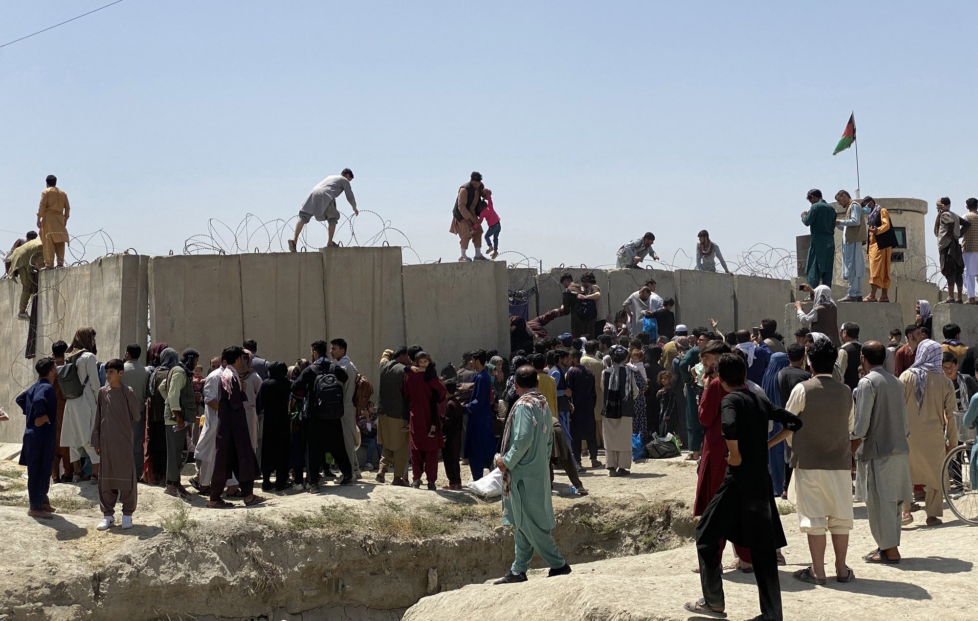 epaselect epa09416177 People struggle to cross the boundary wall of Hamid Karzai International Airport to flee the country after rumors that foreign countries are evacuating people even without visas, after Taliban took control of Kabul, Afghanistan, 16 August 2021. Taliban co-founder Abdul Ghani Baradar Monday declared victory and end to the decades-long war in Afghanistan, a day after the insurgents entered Kabul to take control of the country. Baradar, who heads the Taliban political office in Qatar, released a short video message after President Ashraf Ghani fled and conceded that the insurgents had won the 20-year war.  EPA/STRINGER