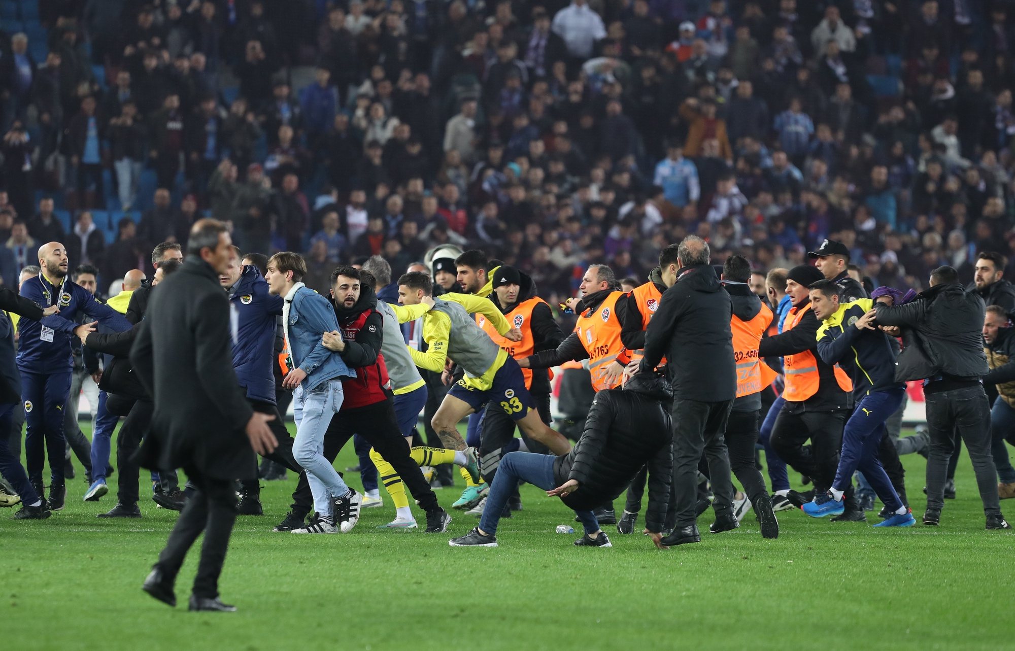 epa11226900 Trabzonspor fans attack Fenerbahce players after the Super League match between Trabzonspor and Fenerbahce in Trabzon, Turkey, 17 March 2024. After Fenerbahce won the match 3-2 against Trabzonspor fans entered the field and began chasing away Fenerbahce players.  EPA/STR