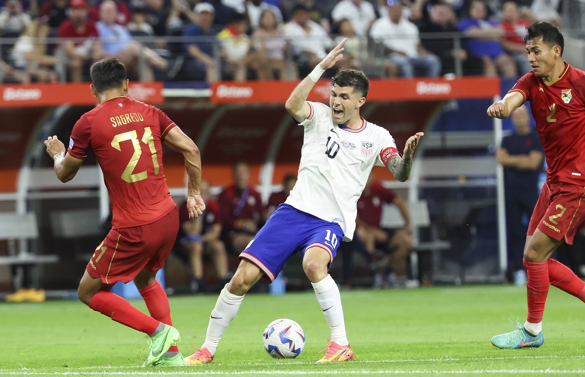 epa11433571 United States forward Christian Pulisic (C) reacts to colliding with Bolivia defender Jose Sagredo (L) as Bolivia defender Jesus Sagredo (R) looks on during the second half of the CONMEBOL Copa America 2024 group C match between USA and Bolivia, in Arlington, Texas, USA, 23 June 2024.  EPA/KEVIN JAIRAJ