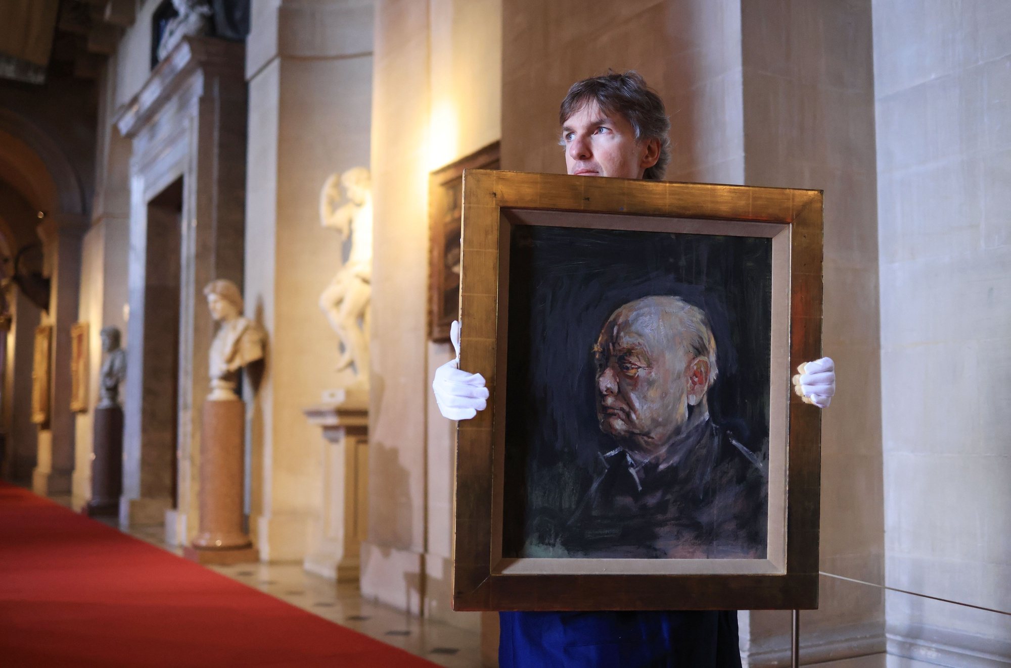 epa11281607 An art handler holds a painting of former British Prime Minister Winston Churchill by artist Graham Sutherland in Blenheim Palace, Britain 16 April 2024. The painting was a preparatory sketch for a painting to be gift from the Houses of Parliament. The finished work was disliked so much by Churchill he had his private secretary destroy it in a fire. The painting can be viewed at Blenheim Palace, Churchill’s birthplace, and will be auctioned on 6 June 2024 by Sotheby’s. It is valued at 500,000 - 800,000 pounds sterling.  EPA/NEIL HALL EMBARGOED UNTIL 1200 BST
