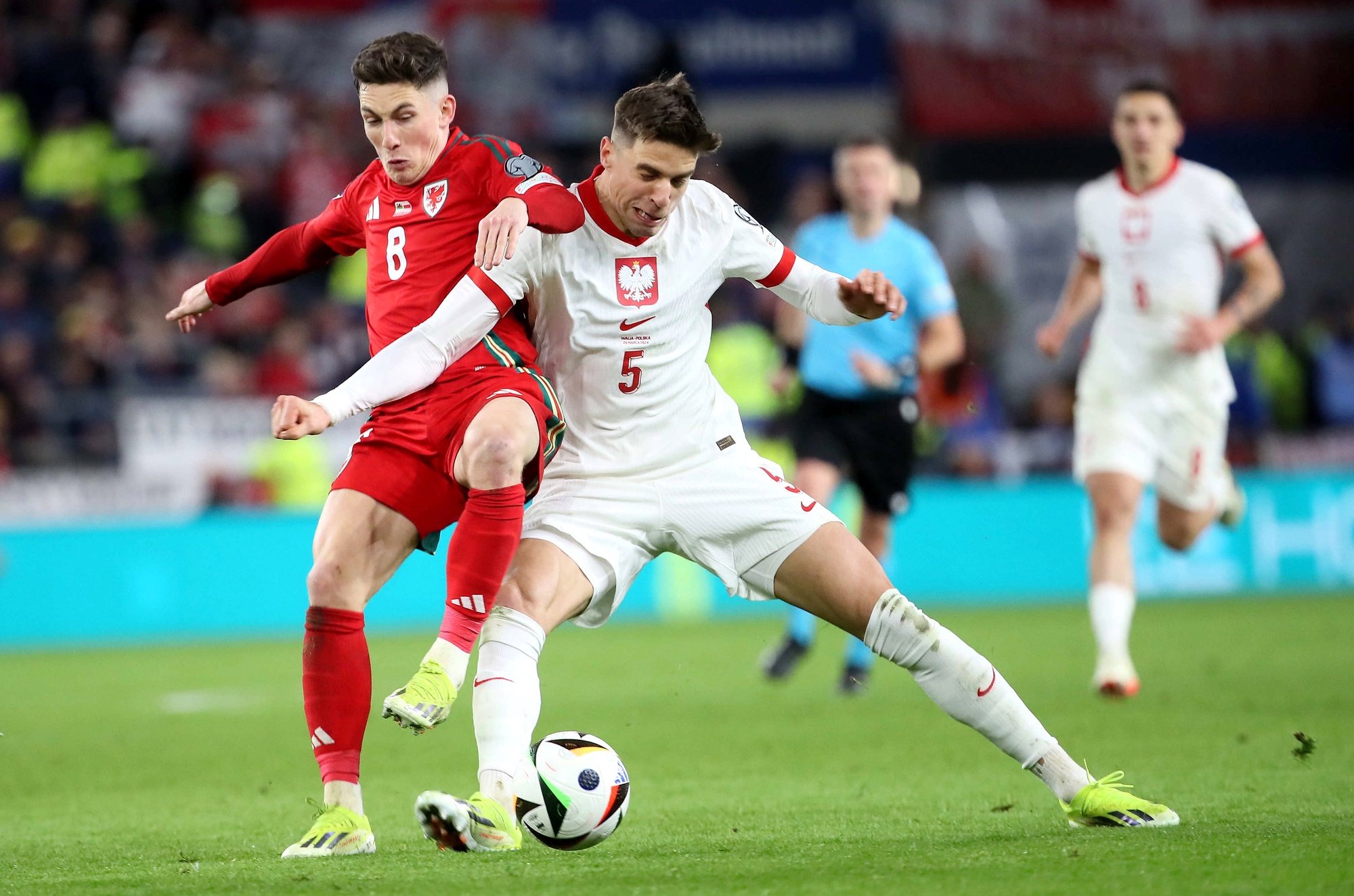 epa11245665 Harry Wilson
 (L) of Wales in action against Jan Bednarek of Poland during the UEFA EURO 2024 play-off between Wales and Poland in Cardiff, Britain, 26 March 2024.  EPA/KARA THOMAS